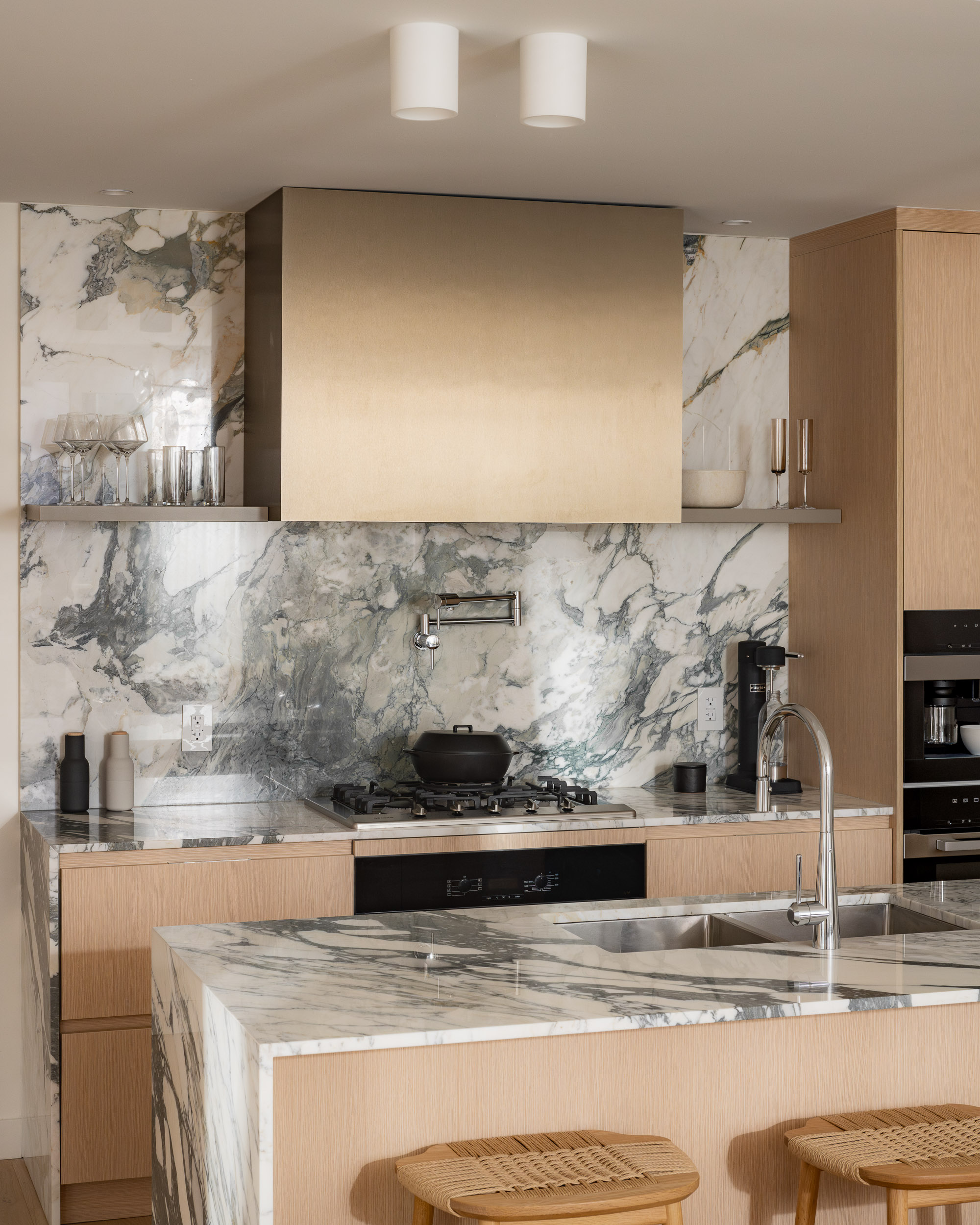 Luxury condo kitchen with marble backsplash and island in Ashleigh Oakridge Vancouver concrete home