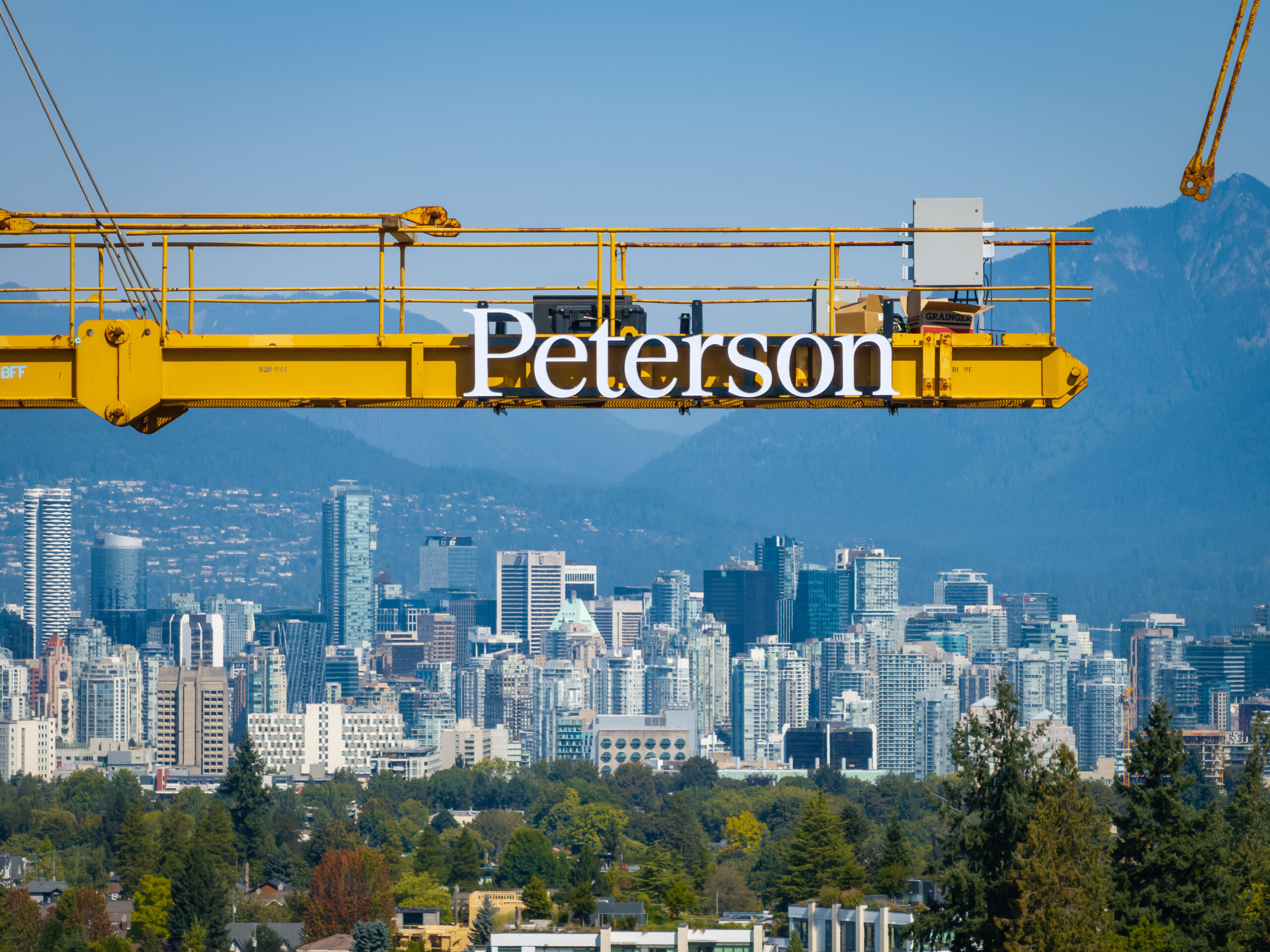 Concrete condo under construction in Vancouver with crane and city skyline